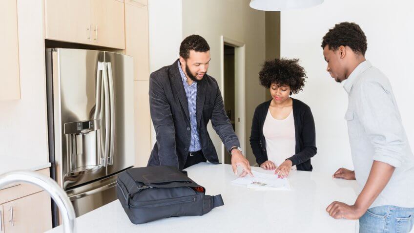 Couple talking to broker in new house.