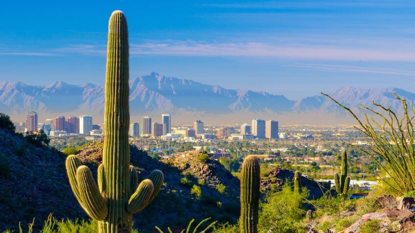 Midtown Phoenix skyline with cacti, mountains, and other desert scenery in the foreground.
