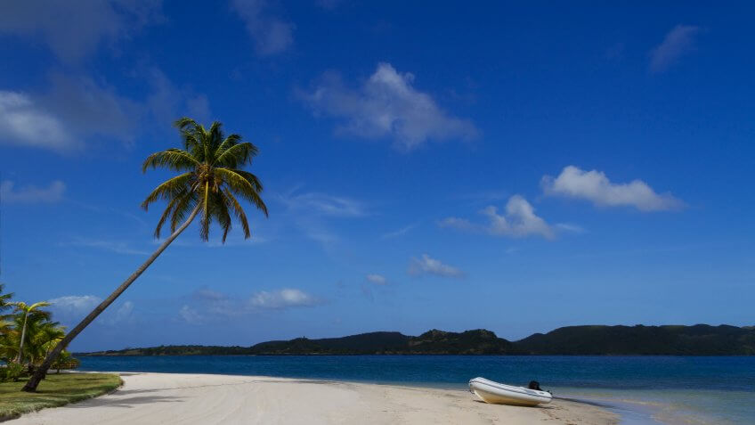 Dingy on shore of beautiful tropical sandy beach at Calivigny Island, Grenada in the Caribbean.