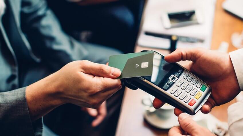 Close up of a card payment being made betweem a man and a waiter in a cafe.