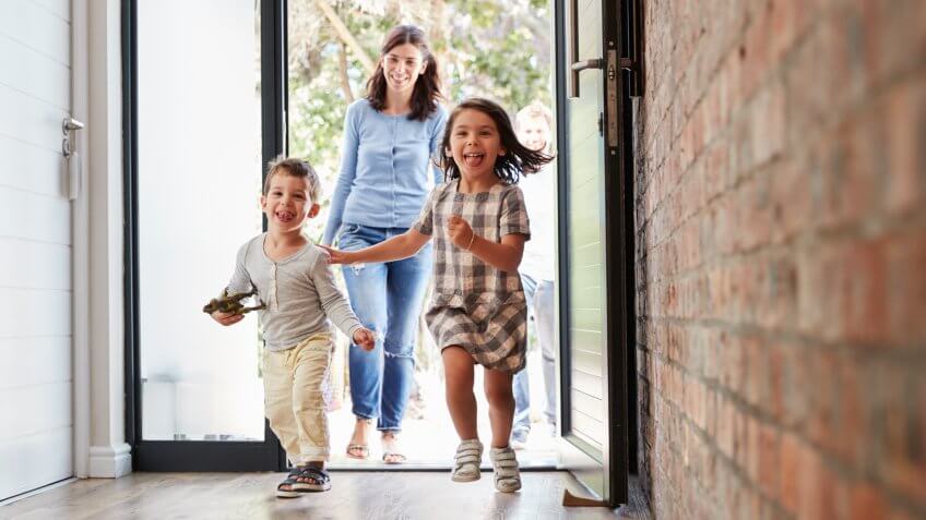 Excited Children Arriving Home With Parents.