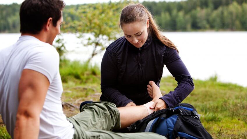 woman-applying-ankle-bandage-on-male