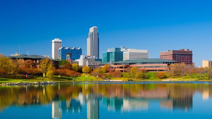 Omaha downtown skyline during Autumn, with a lake at the Heartland of America Park in the foreground.