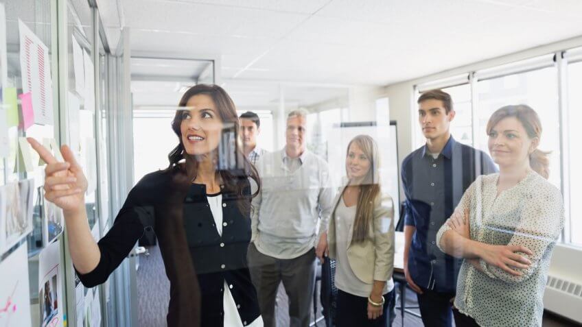 Businesswoman discussing project with colleagues in office.
