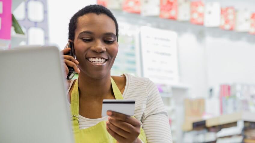 Female small business owner paying for orders over phone.