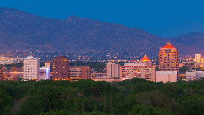 Downtown Albuquerque skyline at dusk with the Sandia Mountains in the background.