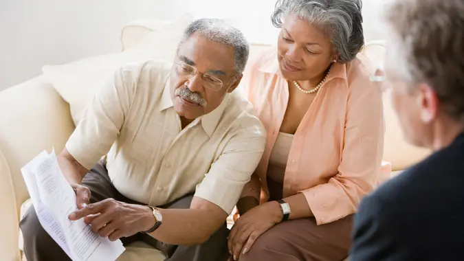African American, Caucasian, Color Image, Friend, Indoors, People, Three People, Woman, african ethnicity, asking, checking, contract, couple, document, girlfriend, heterosexual couple, high angle view, horizontal, husband, livingroom, man, men and women, photography, questioning, representative, retirement, senior adult, side view, sitting, three quarter length, waist up, wife, 11276, Horizontal, advising
