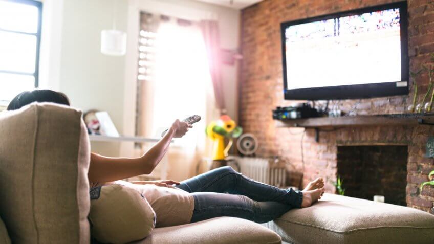 woman relaxing online on sofa reading some papers.