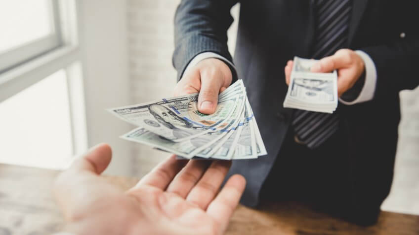businessman-giving-money-us-dollar-bills