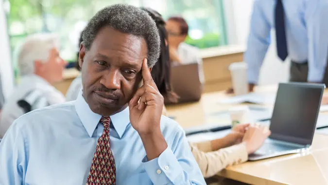 Concerned African American businessman worried during business meeting.