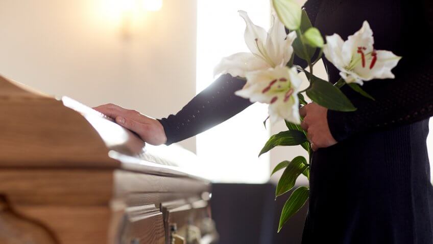 person mourning with flowers in hand