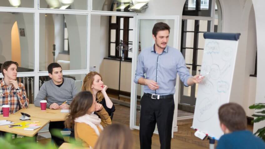 Group of university student sitting in classroom, listening to lecture.
