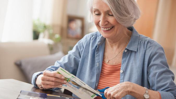 Senior woman clipping coupons.