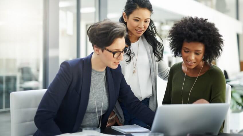 group of businesswomen using a laptop during a meeting at work