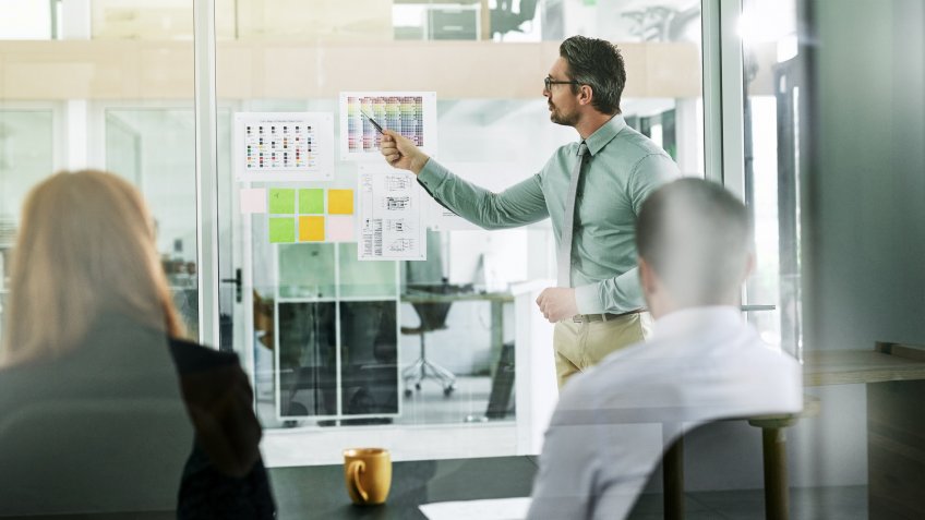 businessman giving a presentation to his colleagues in an office