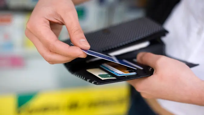Close-up of a woman getting a credit card out of her wallet.
