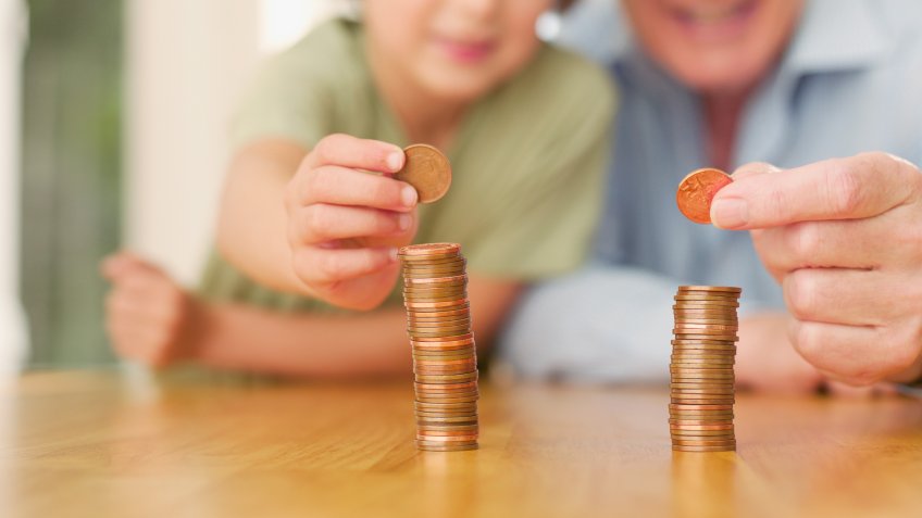 Grandfather and grandson stacking coins.