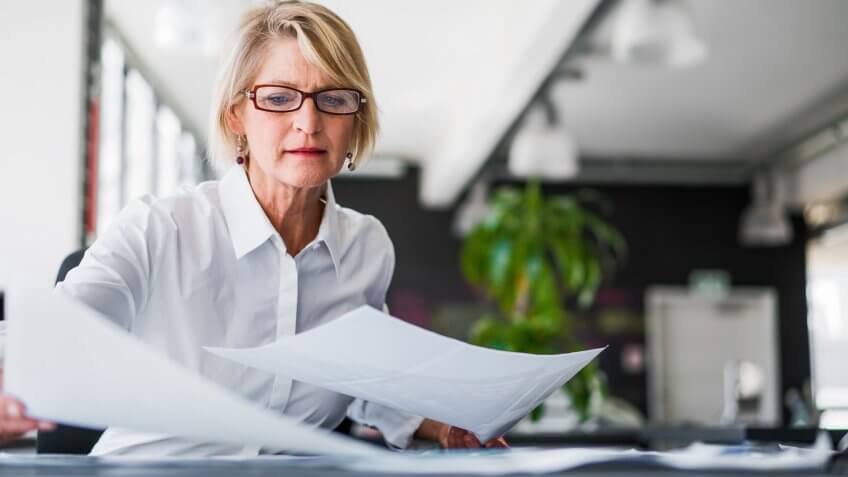 businesswoman examining documents at desk