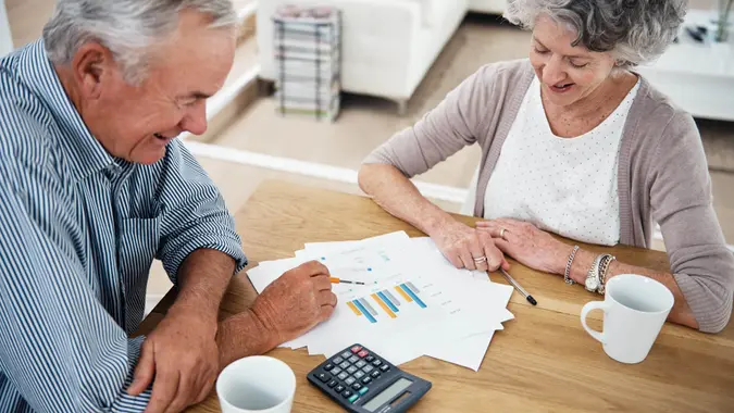 Cropped shot of a senior couple reviewing their financial investments