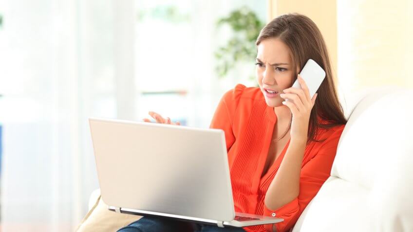 Angry woman calling to customer service with a laptop failure.