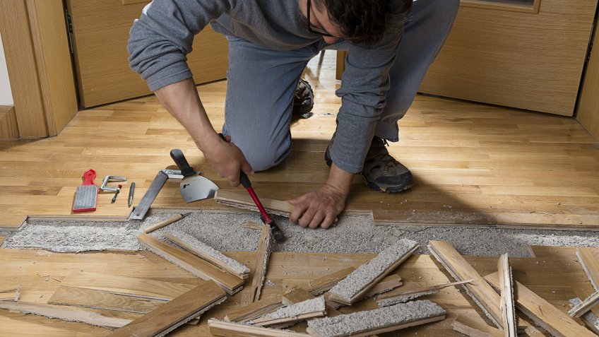 manual-worker-disassembling-wooden-floor-ruined