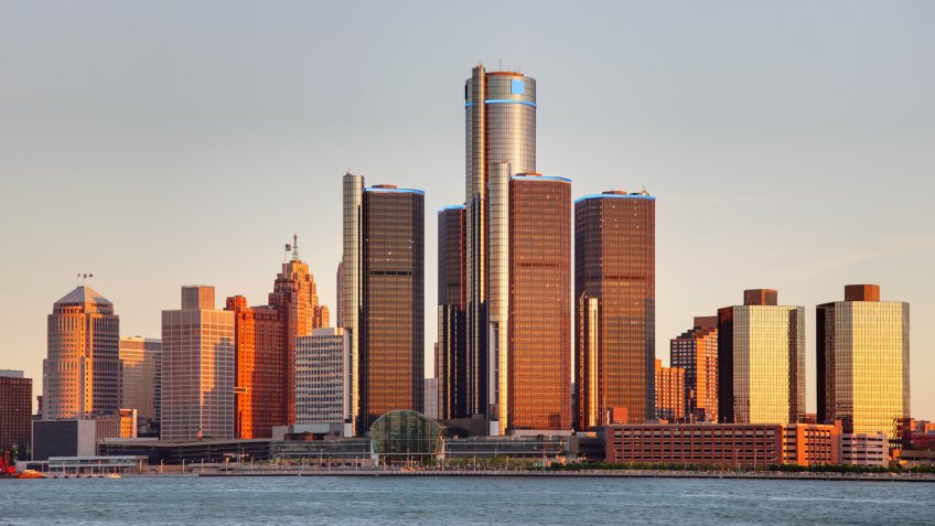 Detroit city skyline along the Detroit River at dusk.