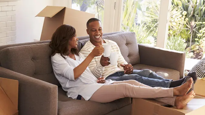 Couple on a sofa taking a break from unpacking their home, apartment or house.