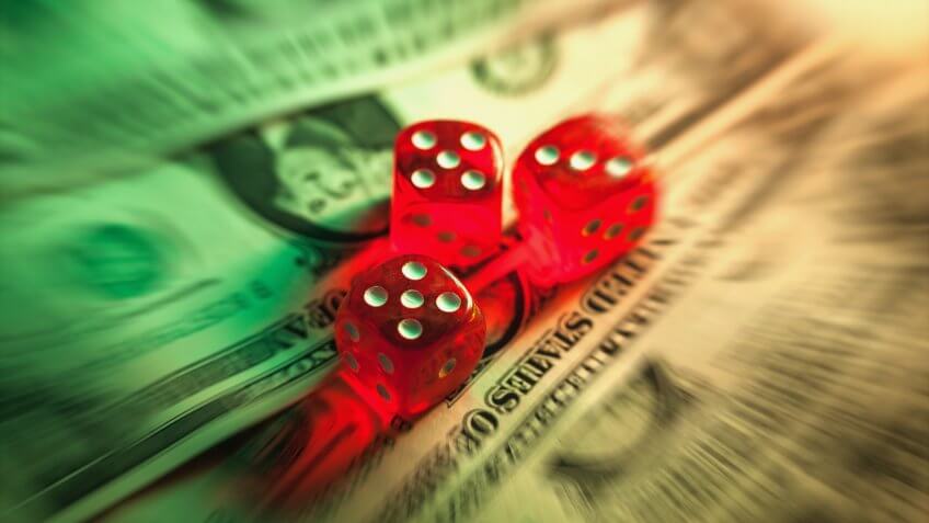 Dollar with dices illuminated with low light in radial blur.