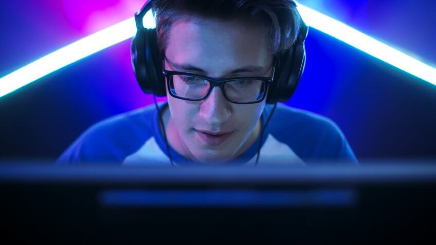 Professional Gamer Plays in MMORPG/ Strategy/ Shooter Video Game on His Computer.