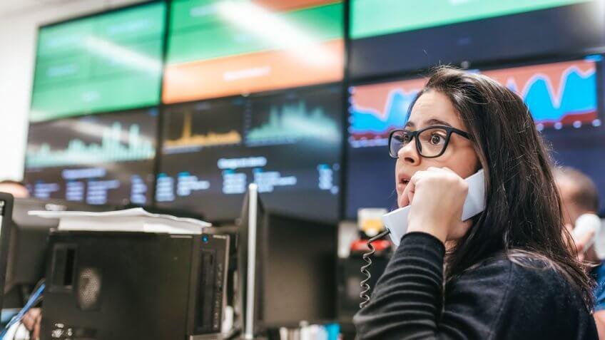 business woman talking at telephone in front of carts with business data in office