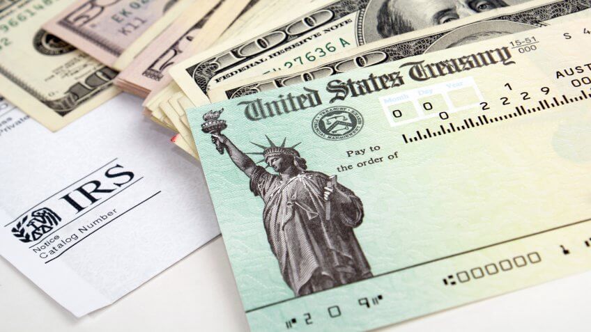 Close-up of tax return check and USA currency.