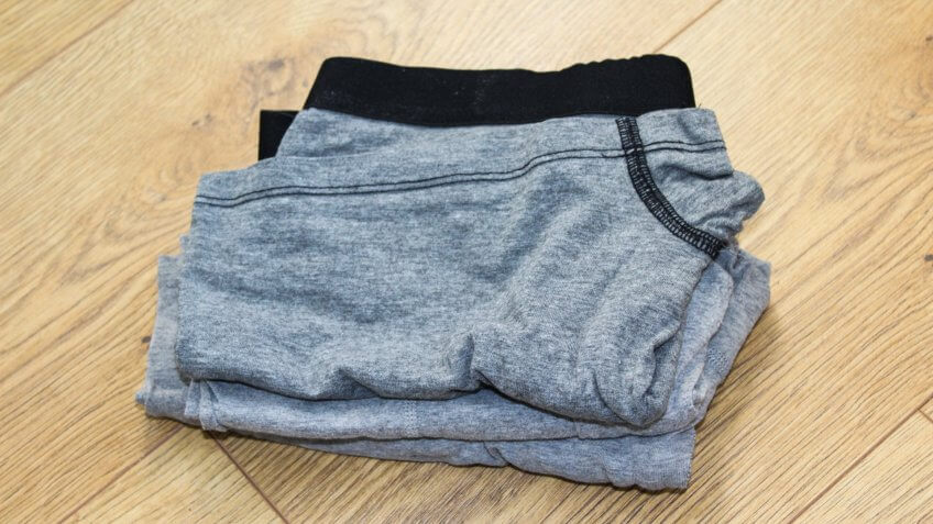 close up of Stack of gray folded underwear, on wooden background.