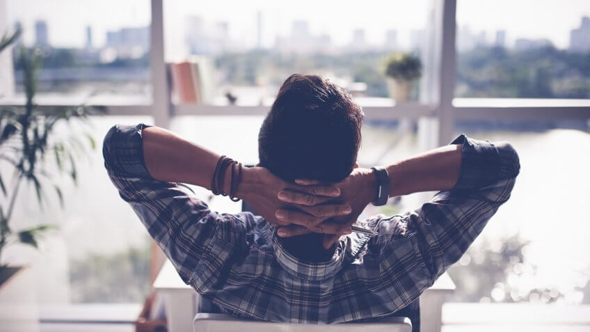 Man relaxing in his chair and enjoying the view from office window.