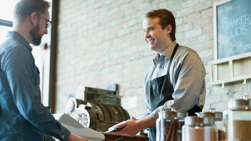 2 person, 20s, 30s, Antique, Buying, COMMERCE, Candid, Caucasian Ethnicity, Customer, Indoors, Male, Merchandise, Mid-adult man, Millennial, Natural products, Old-fashioned, Retail, Small Business, Smiling, Standing, WINDOWS, Young adult man, anti-oxidants, aroma, cash register, choices, city, daytime, debit, earthy, glass, half length, health conscious, jars, looking at each other, merchant, nostalgic, payment, selection, shopping, spices, store, tins