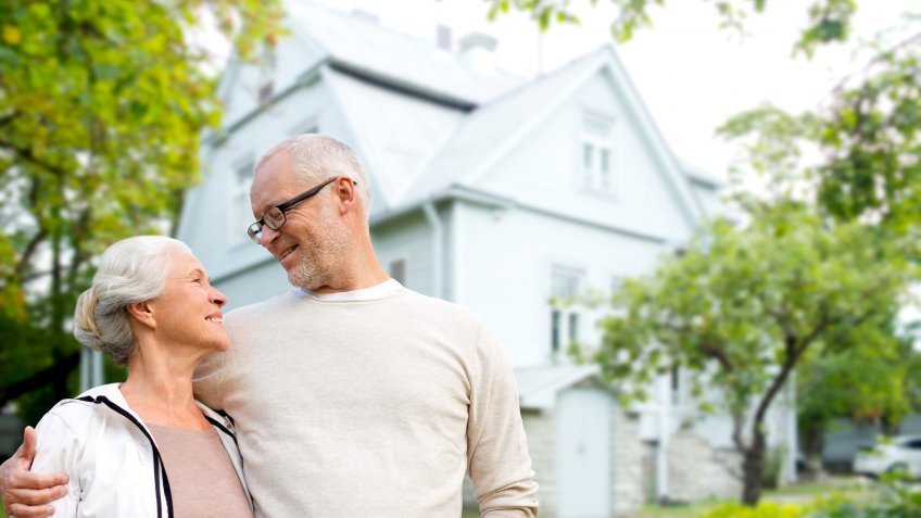 family, age, home, real estate and people concept - happy senior couple hugging over living house background.