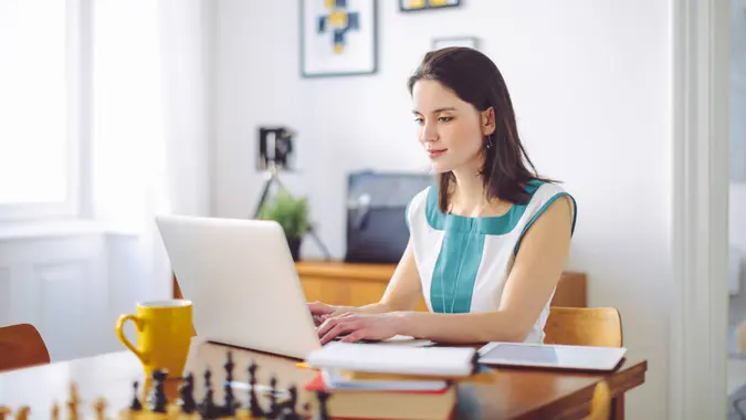 A woman works on her laptop at home.