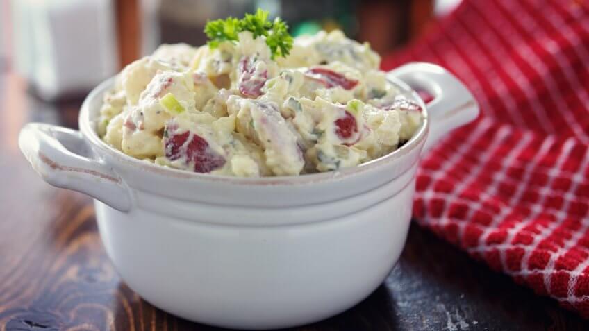 american potato salad with parsley garnish.