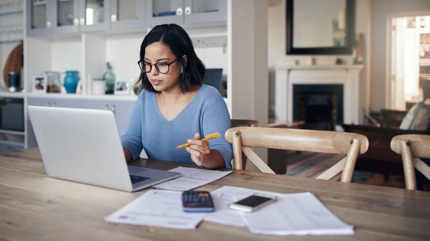 Shot of a young woman using a laptop while working from home.
