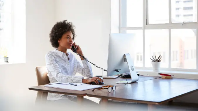 woman talking on phone at her desk in an office