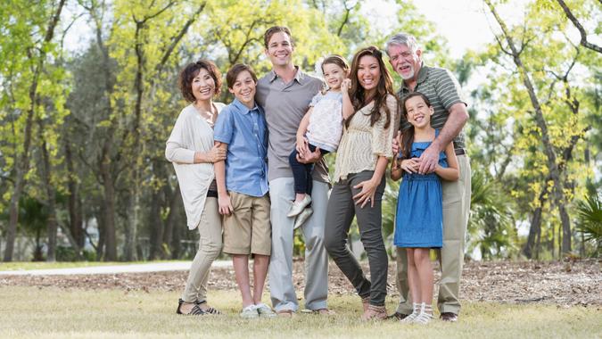 Portrait of a multi-generation family standing together outdoors, at the park.