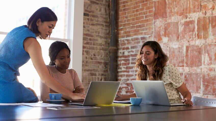 Group Of Businesswomen Working Together In Boardroom.