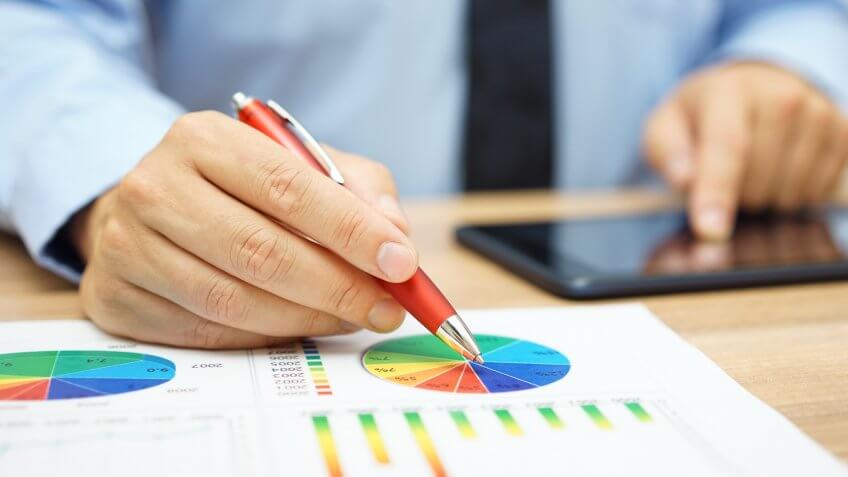 financial worker analyzing business data and working with tablet computer.