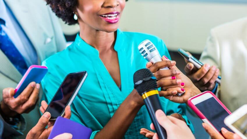 Smiling african american woman speaks to the media.