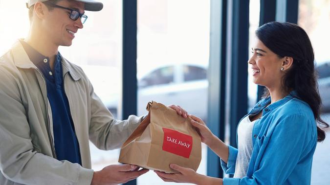 Shot of a man making a takeaway delivery to a woman.