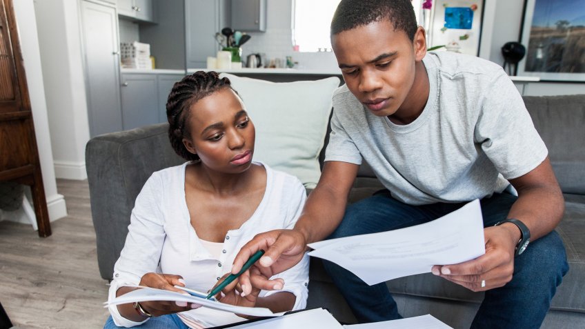 Young african female and male couple at home working on their finances together.
