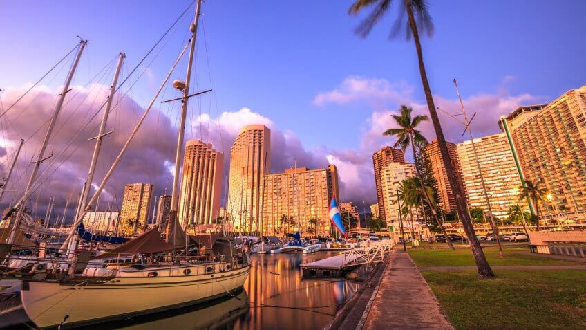 Beautiful panorama of sailing boats docked at the Ala Wai Harbor the largest yacht harbor of Hawaii and Honolulu skyline at twilight.