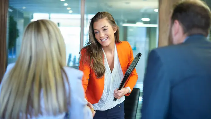 a young graduate walks into an interview room full of confidence and positivity energy .