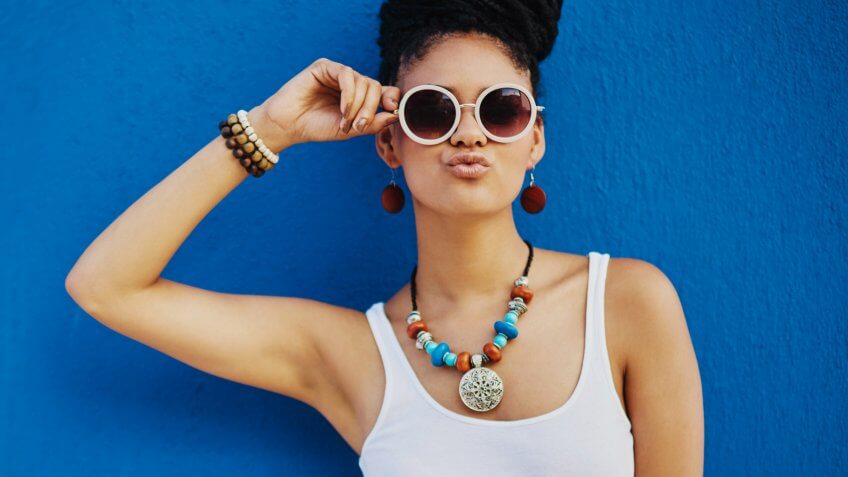 Shot of an attractive young woman wearing funky sunglasses against a blue backgroundhttp://195.