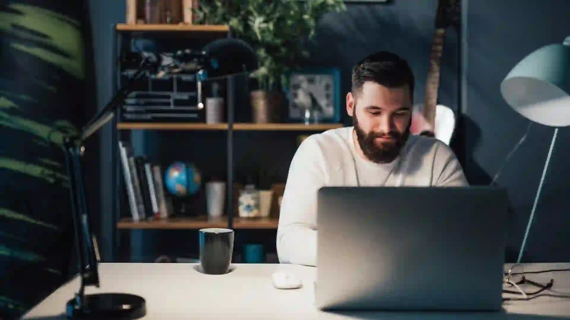 man working on laptop on his finances and emergency fund
