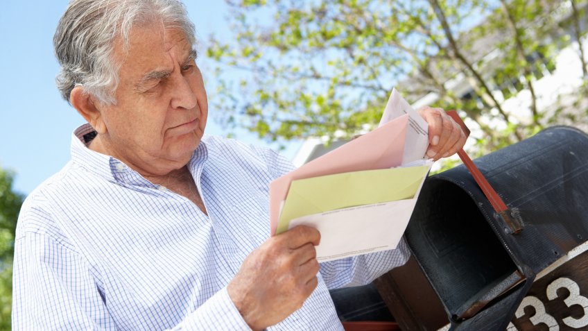senior-man-checking-mail-bills